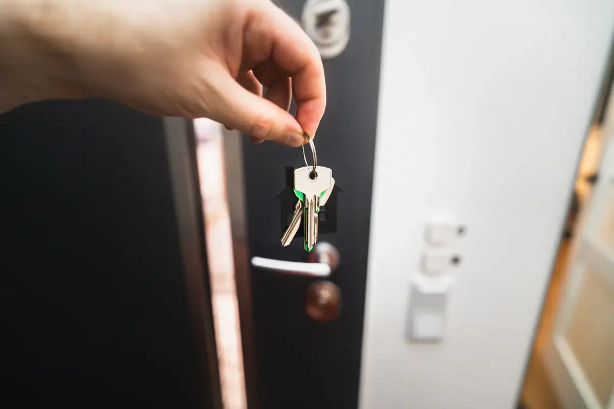 Main tenant des clés devant une porte